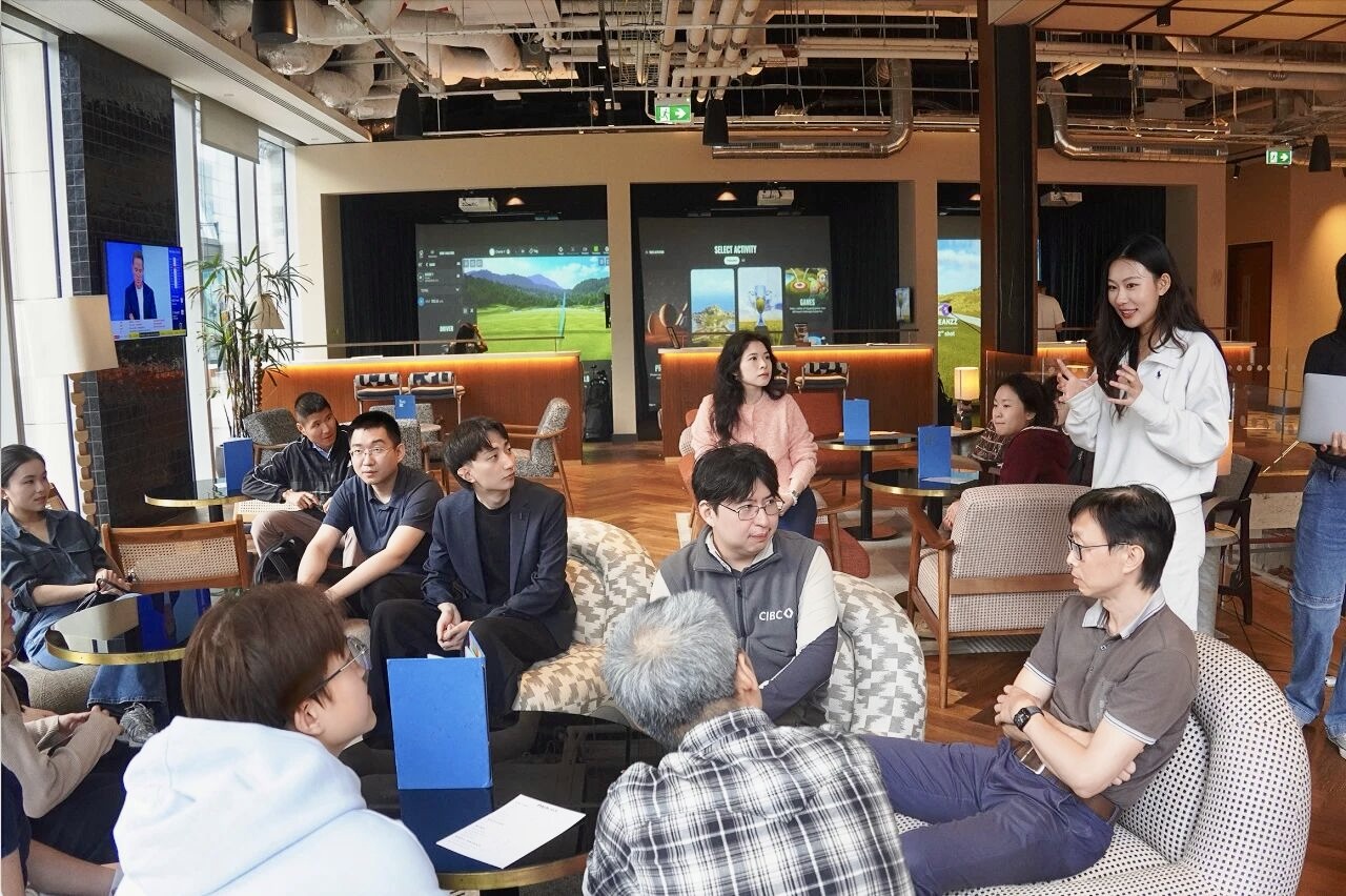 Members gathered in a golf simulator lounge, talking together